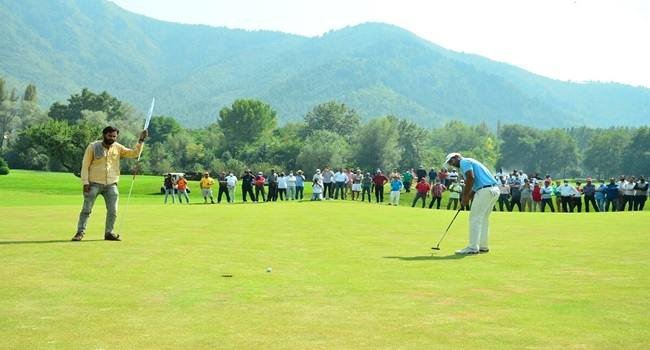 Gulmarg Golf Course in Kashmir with snow-capped Pir Panjal mountains